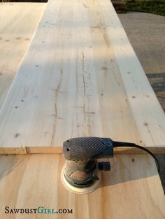 an electric sander is on top of a wooden planked table that has been made into a bench