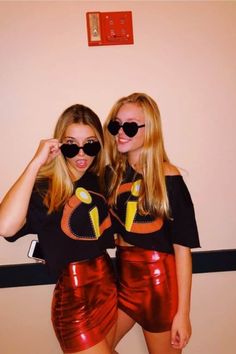 two young women in matching outfits posing for the camera with sunglasses on their faces and one wearing