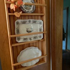 a wooden shelf with plates and bowls on it