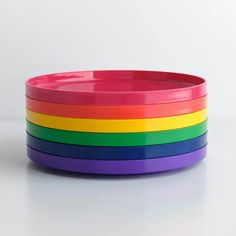 a stack of rainbow colored plates on a white surface