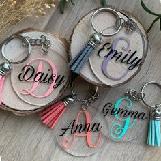 three personalized acrylic keychains with tassels on wood slices