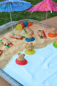 there is a cake made to look like a beach scene with teddy bears in the sand