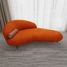 an orange couch sitting on top of a carpeted floor next to a white curtain