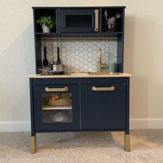 a blue kitchen cabinet with gold handles and knobs on the doors is open to reveal a sink