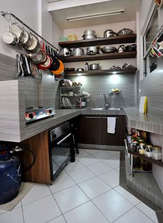 a kitchen with pots and pans on the shelves above the stove, sink and oven