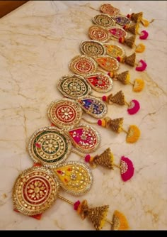 a row of colorful necklaces sitting on top of a marble counter next to each other