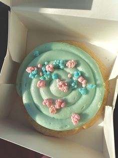 a cupcake with frosting and sprinkles in a box