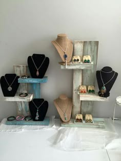 several necklaces are displayed on wooden shelves