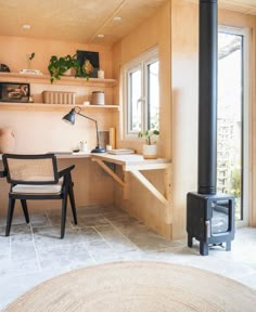 a living area with a chair, desk and wood stove