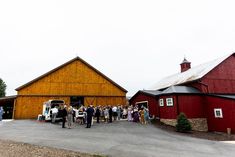 a group of people standing in front of a barn