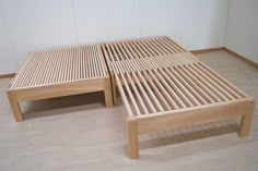 two wooden beds sitting next to each other on top of a hard wood floored floor