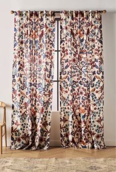 the curtains are open and ready to be hung in front of a window with an ornate pattern on it