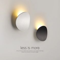 two circular lights are on the wall next to each other, which says less is more