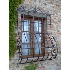 a window with iron bars in front of a stone building