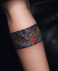 a tattoo on the arm of a person with a dragon design on it's wrist