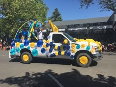 a truck decorated with blue and yellow pom poms