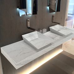 a bathroom with two sinks and mirrors on the wall