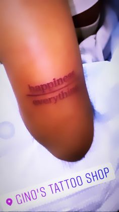 a tattoo saying happiness is everywhere on someone's leg