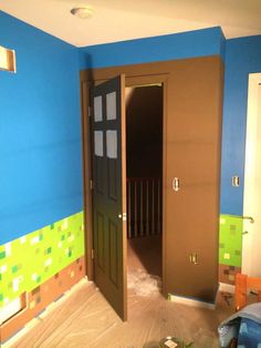 an open door in a room that is being painted blue and brown with green squares on the walls