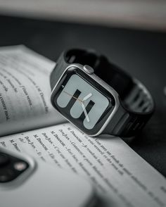 an apple watch sitting on top of an open book