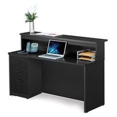 a computer desk with a laptop on top of it next to a potted plant