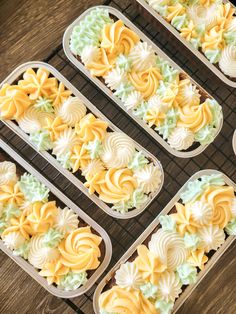 four trays filled with cupcakes on top of a wooden table