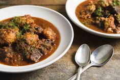 two white bowls filled with meat and gravy