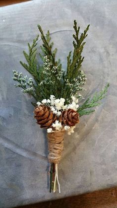 a bunch of pine cones and flowers tied to a piece of string on a table