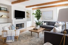 a living room filled with furniture and a flat screen tv mounted on the wall above a fireplace