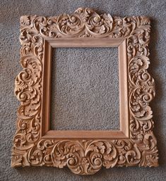 an ornate wooden frame sitting on the floor