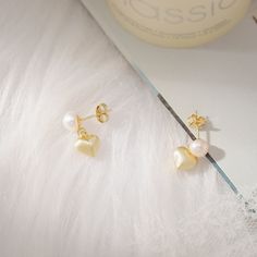 Experience love's essence with our Pearl Heart Earrings. Delicately dangling freshwater pearls grace heart-shaped charms made from 18K gold-plated sterling silver. Symbolizing eternal affection, they capture nature's radiance. Versatile for any occasion, they infuse stylish charm into your ensemble, reminding you to cherish life's moments. Let their grace illuminate your inner warmth, indulging in the timeless allure of pearls as these earrings steal your heart. DETAILS Plating: 18K Gold  Mate Heart Shaped Pearl Earrings As Gift, Gold Pearl Heart Earrings For Weddings, Valentine's Day Pearl Drop Earrings For Anniversary, Valentine's Day Anniversary Pearl Drop Earrings, Heart Charm Pearl Earrings For Gift, Heart Charm Pearl Earrings As A Gift, Gold Teardrop Heart Charm Earrings, Pearl Drop Dangle Heart Earrings For Anniversary, Dangle Pearl Earrings For Valentine's Day