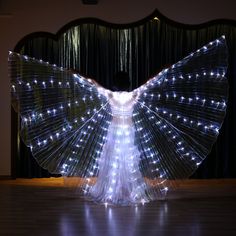 a woman is dancing with lights on her wings