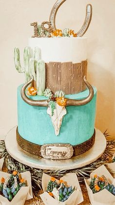 a three tiered cake with cactus decorations on top