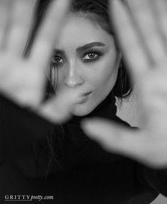 a black and white photo of a woman with her hands in the air