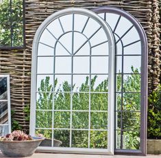 an arched glass window sitting next to a potted plant