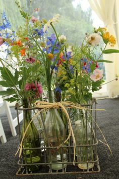 three vases filled with flowers sitting on top of a table