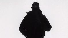 the silhouette of a person wearing a black coat