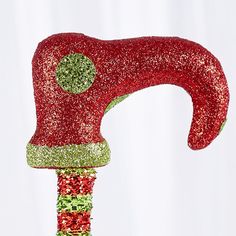 a close up of a red and green glittered object with a hammer sticking out of it