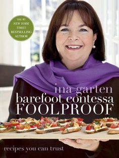 the cover of barefoot contessa foolproof cookbook shows a smiling woman holding two trays of food