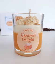 a glass filled with caramel delight on top of a table