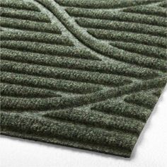 a green rug with wavy lines on the top and bottom, in an angled position