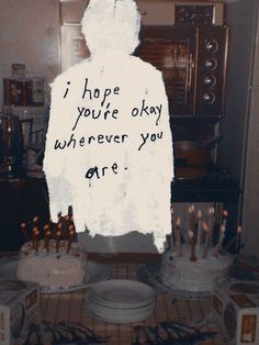 a person standing in front of a cake with candles on it that says i hope you're okay wherever you are