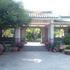 an entrance to a house with flowers and trees