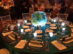 a table set with plates and silverware for an elegant dinner party in a banquet hall