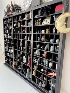 a shelf filled with lots of different types of figurines on top of it