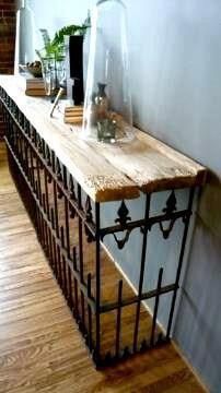 a long wooden table sitting on top of a hard wood floor next to a wall