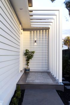 an instagram photo of a white house with a plant on the front porch and door