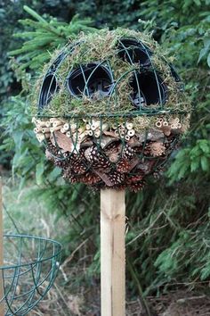 a bird feeder filled with lots of pine cones and other things on top of it