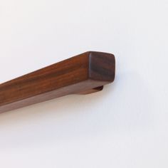 a close up of a wooden handle on a white wall