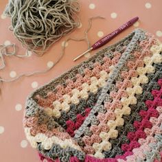 a crocheted bag sitting on top of a table next to a ball of yarn